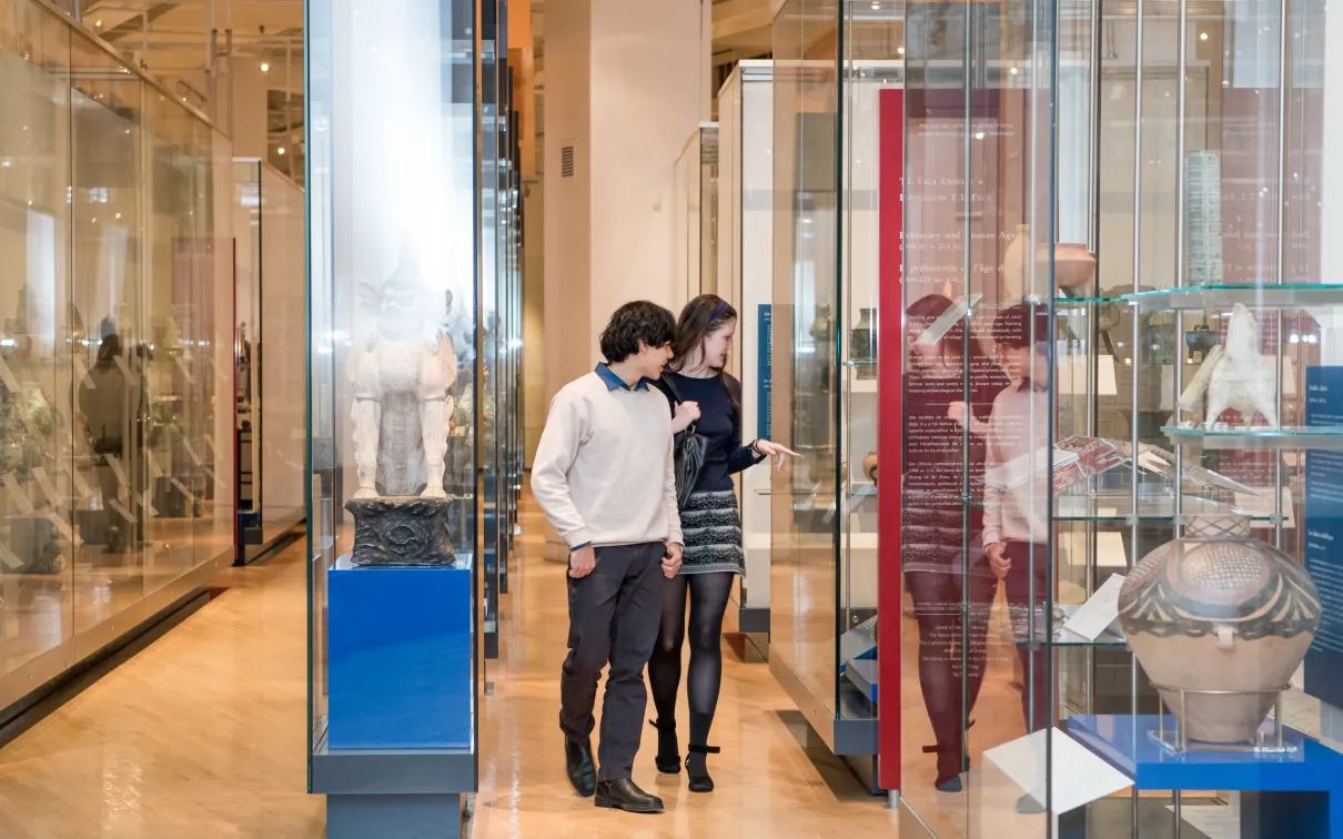 A young couple walk through the China gallery looking at objects 