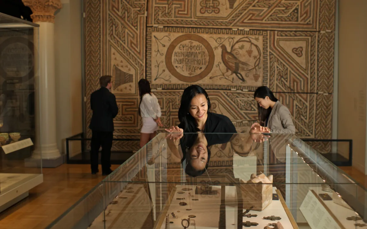 Visitor looking at artifacts in encased glass