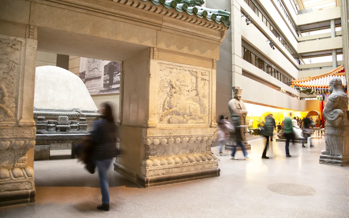 Gallery of Chinese Architecture People walk through a gallery with a large entry gate