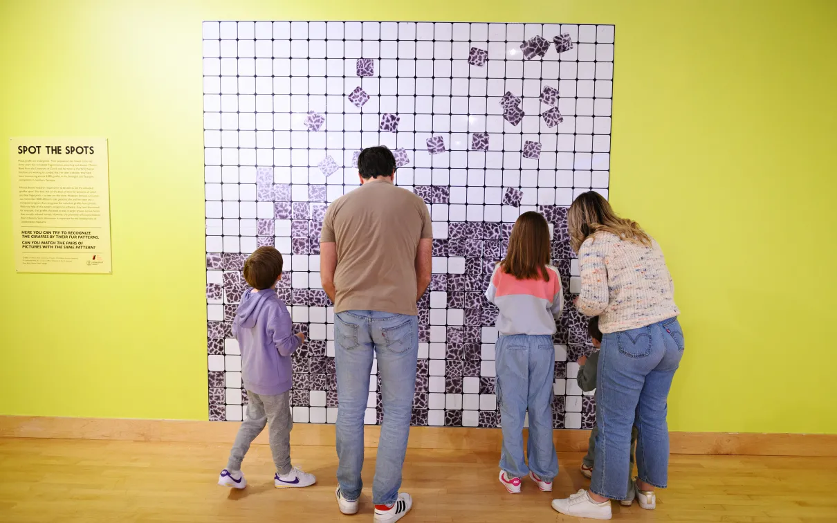 Family enjoying Spot the Spots wall at THEMUSEUM