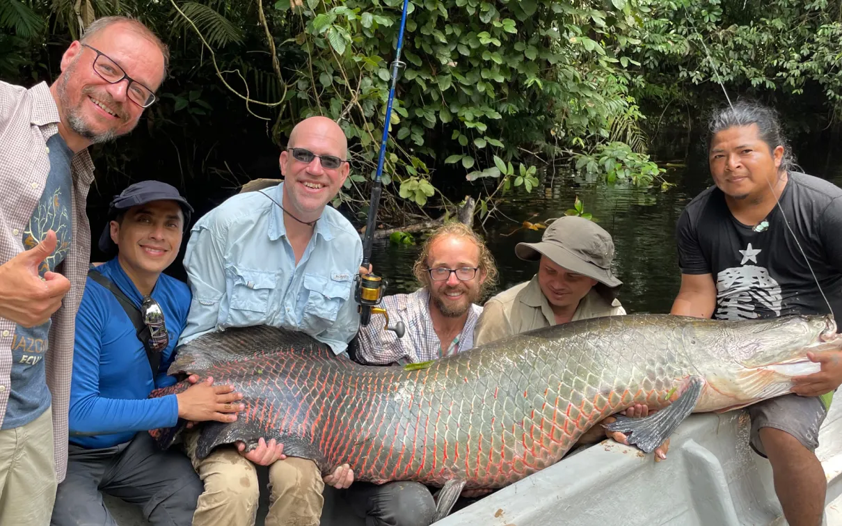 The crew is all smiles as they display their big catch—a two-metre, 200-pound Arapaima.