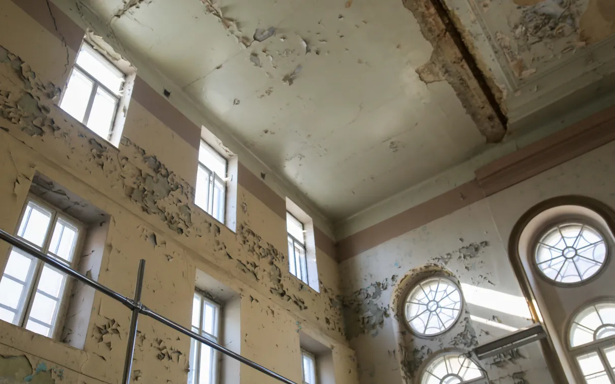  building's deteriorating interior wall and ceiling.