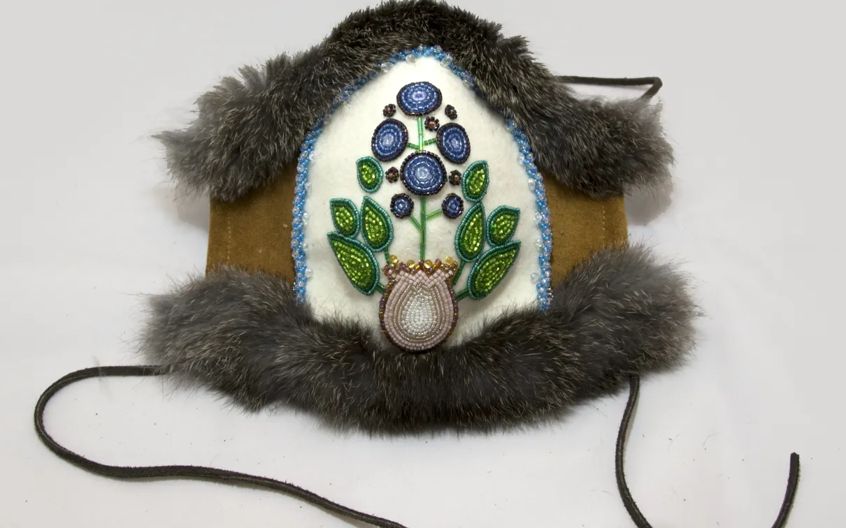 A mask created with beeds in the shape of a blue berry
