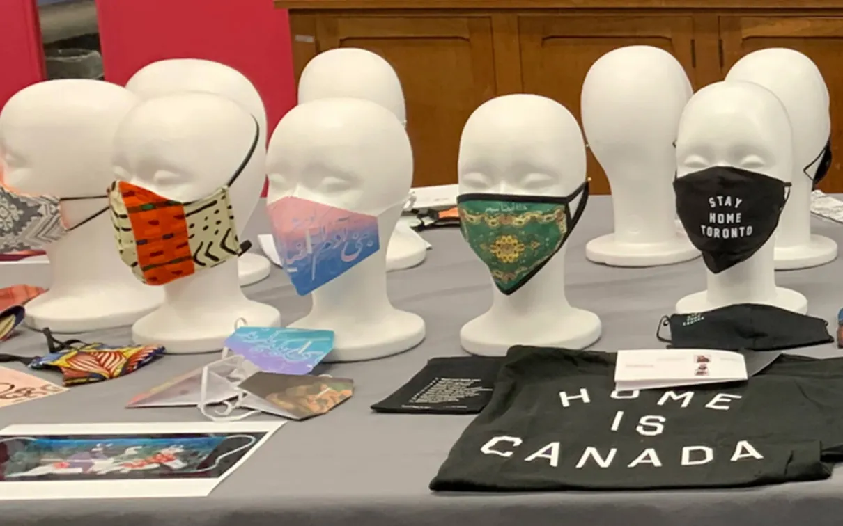 An array of mannequins on a table wearing face masks.