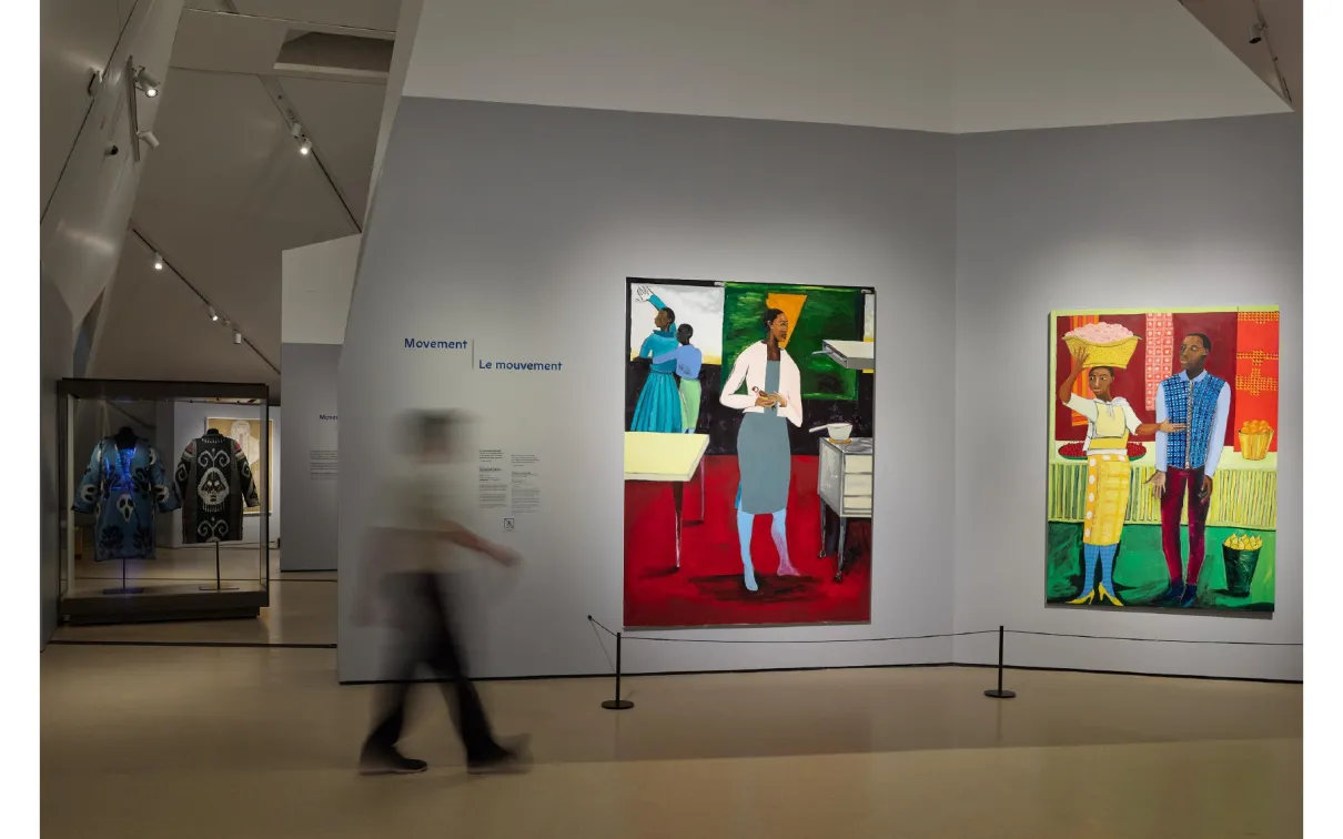 In-gallery image of 2 colourful paintings with person walking