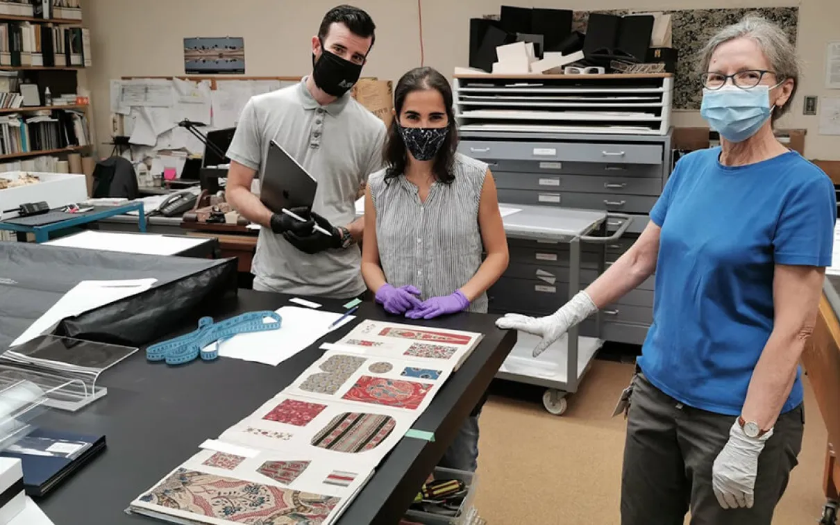 Conservateurs et techniciens du ROM travaillant sur le contenu de l'exposition Cloth the Changed the World.
