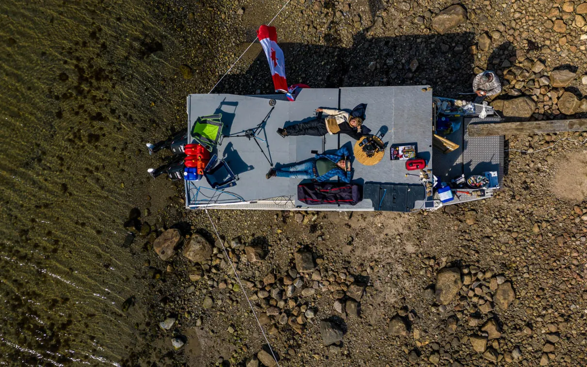 Two people relaxing on the roof of their camp.