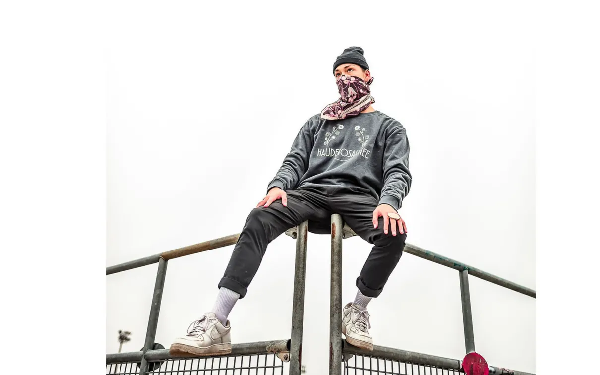 Masked person sitting on bleachers.