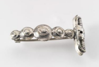A silver brooch with spiral decorations
