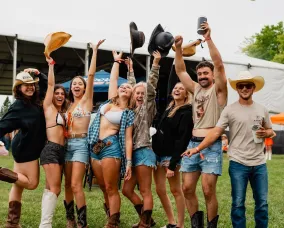 A group of people throwing up cowboy hats in joy.